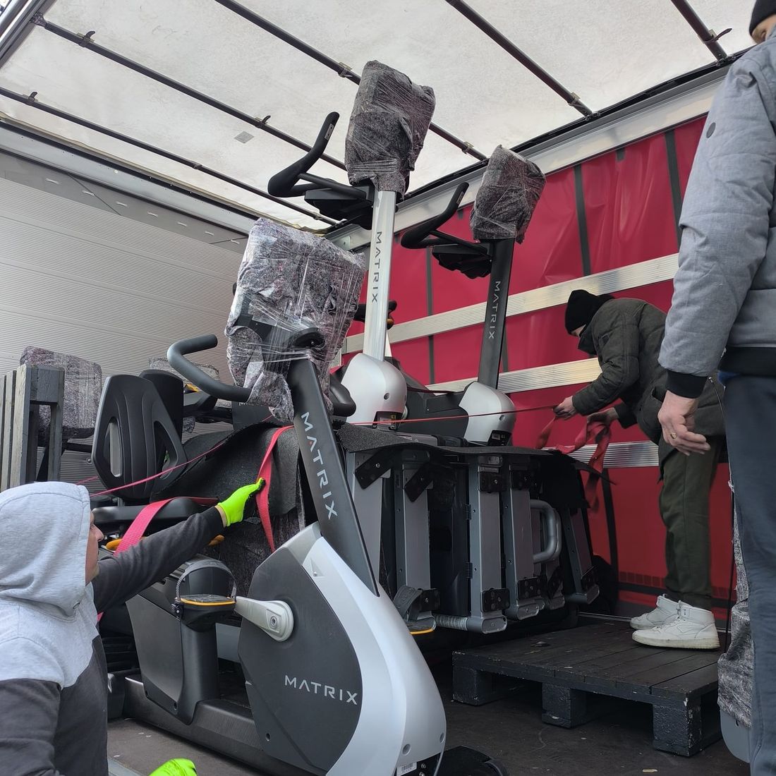 Vélo ergomètre arrimé dans le camion avec sangles et couvertures de protection