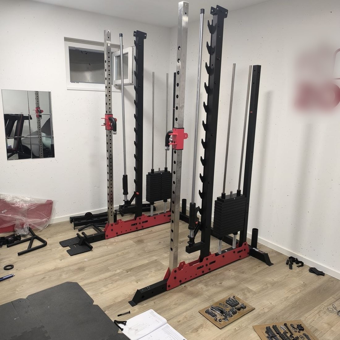 Cable station part-way through assembly: frame standing, weight stacks and guide rods fitted