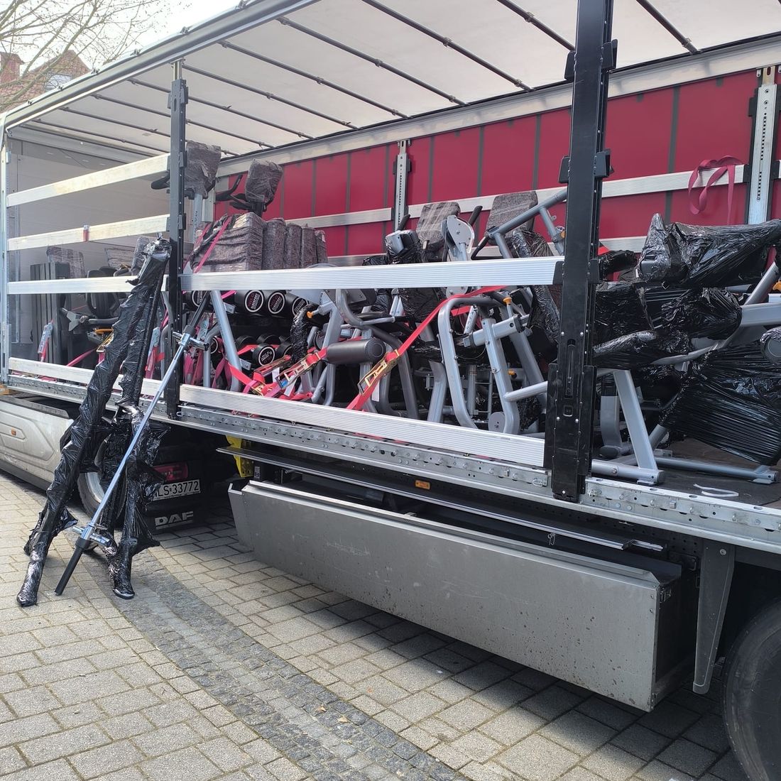 Camion chargé d’appareils de musculation emballés, arrimés sur deux niveaux