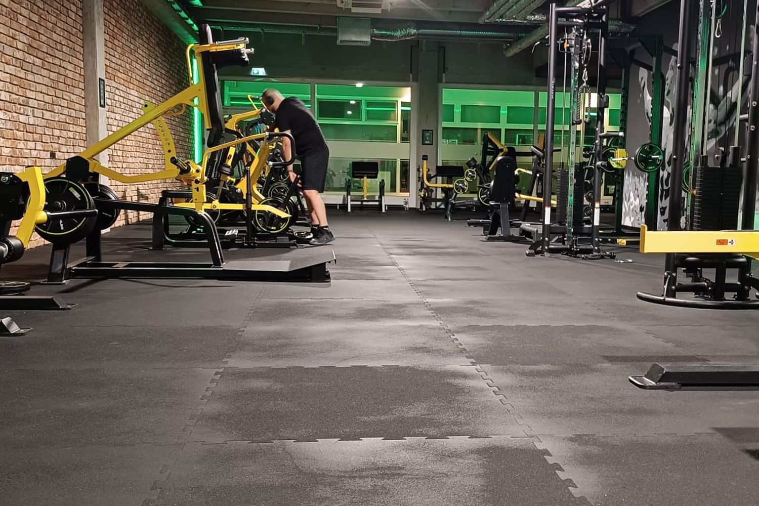Clubflaach mat gréngem Liicht, plate-loaded Geräter a Racken, Techniker am Hannergrond