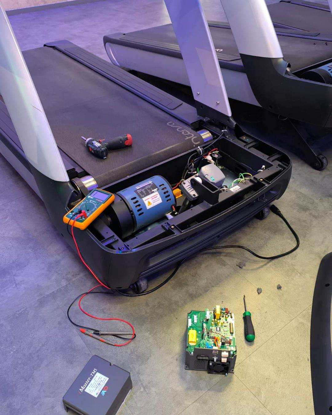 Elektronikdiagnos un engem Laafband: opgemaachten Motorhaap, Multimeter um Motor, ausgebauten Steierprint um Buedem