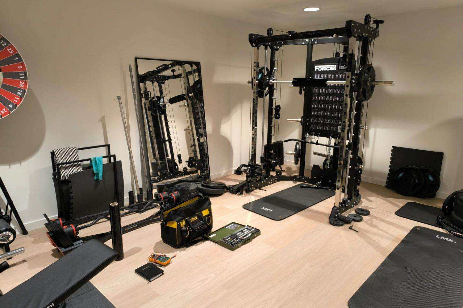 Multistation dans un home gym privé, sacoche à outils et coffret de douilles posés au sol