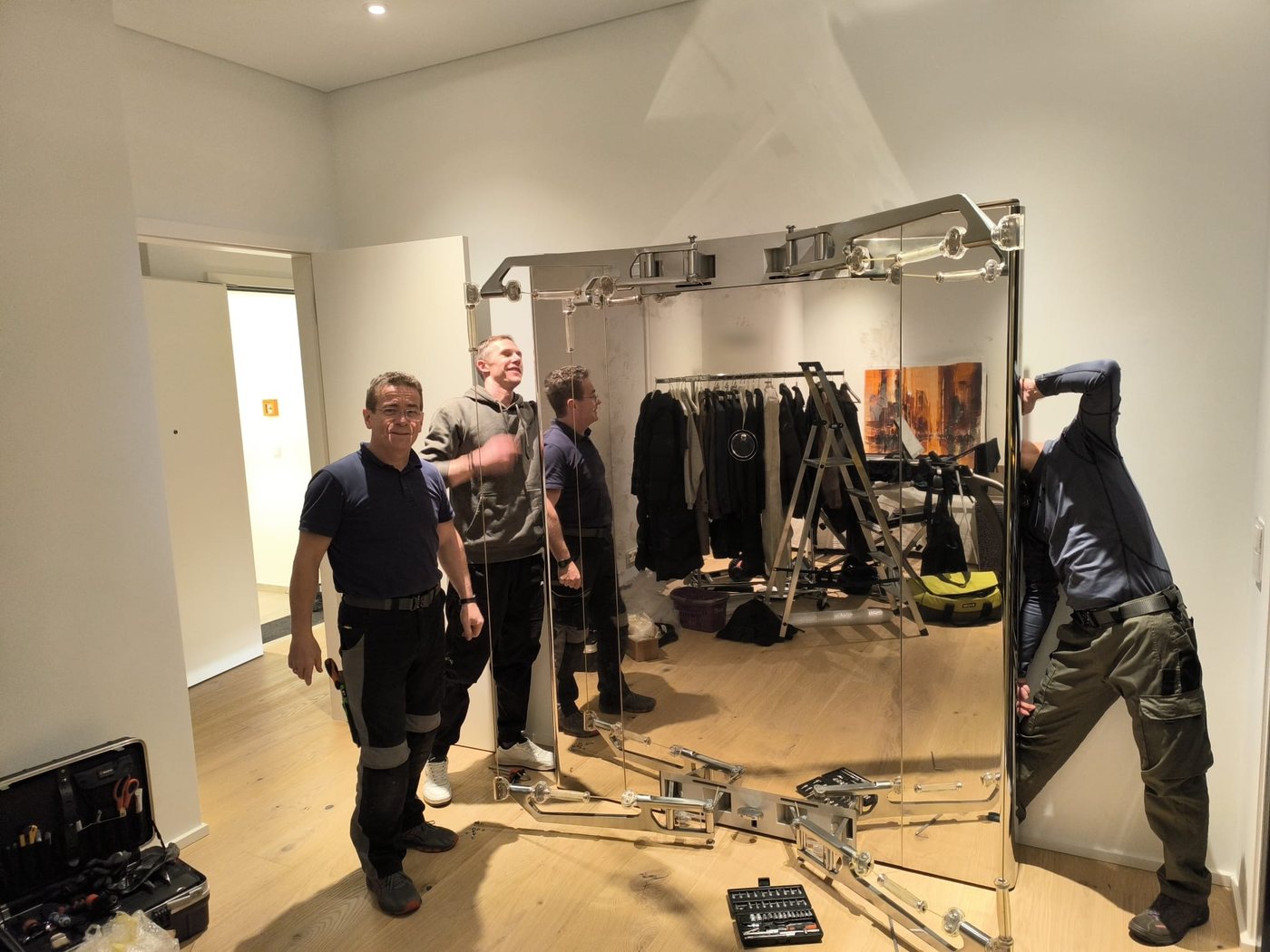 Trois techniciens de Gym Service montent une station de musculation à façade miroir dans une salle privée