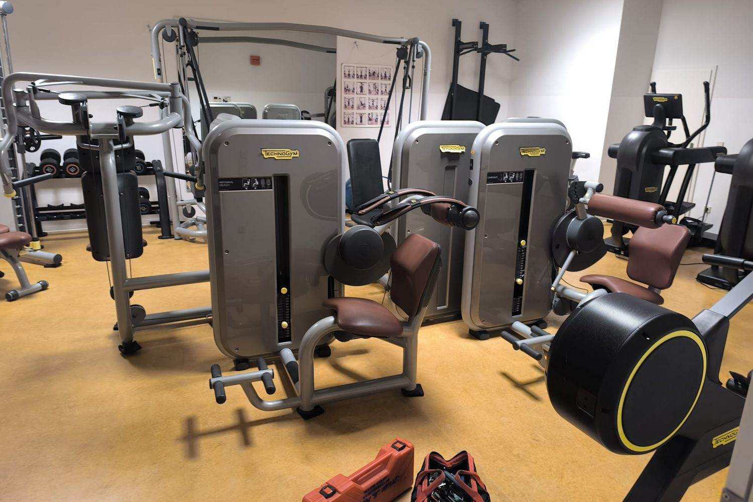 Equipped training room with selectorized machines, a cable station, a dumbbell rack and a cross trainer