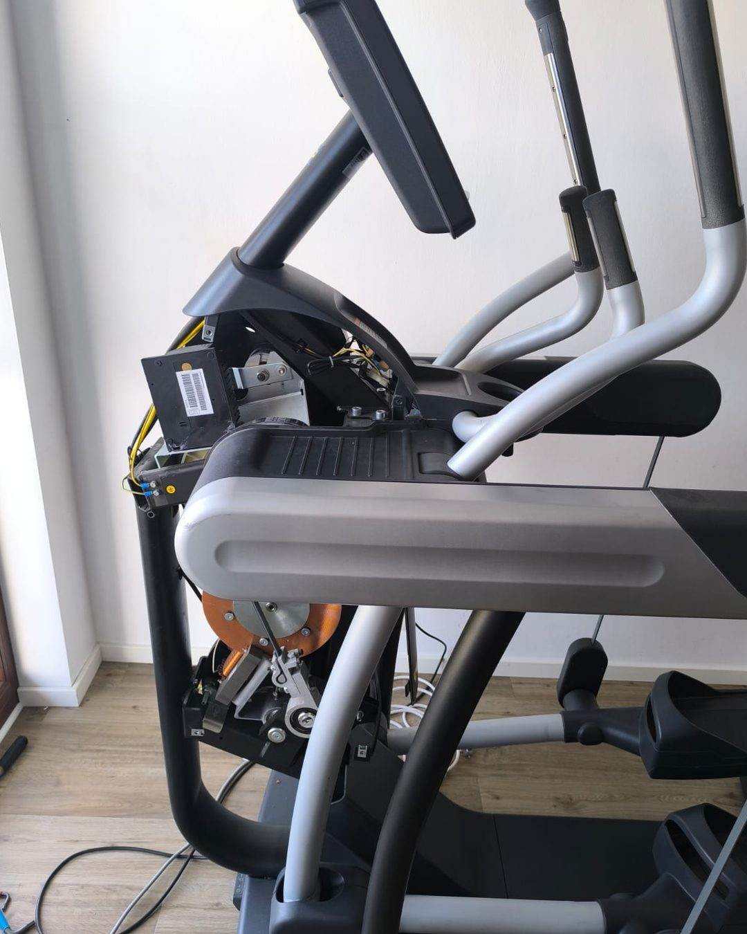 Cross trainer opened during repair: console removed, electronics and drive unit exposed