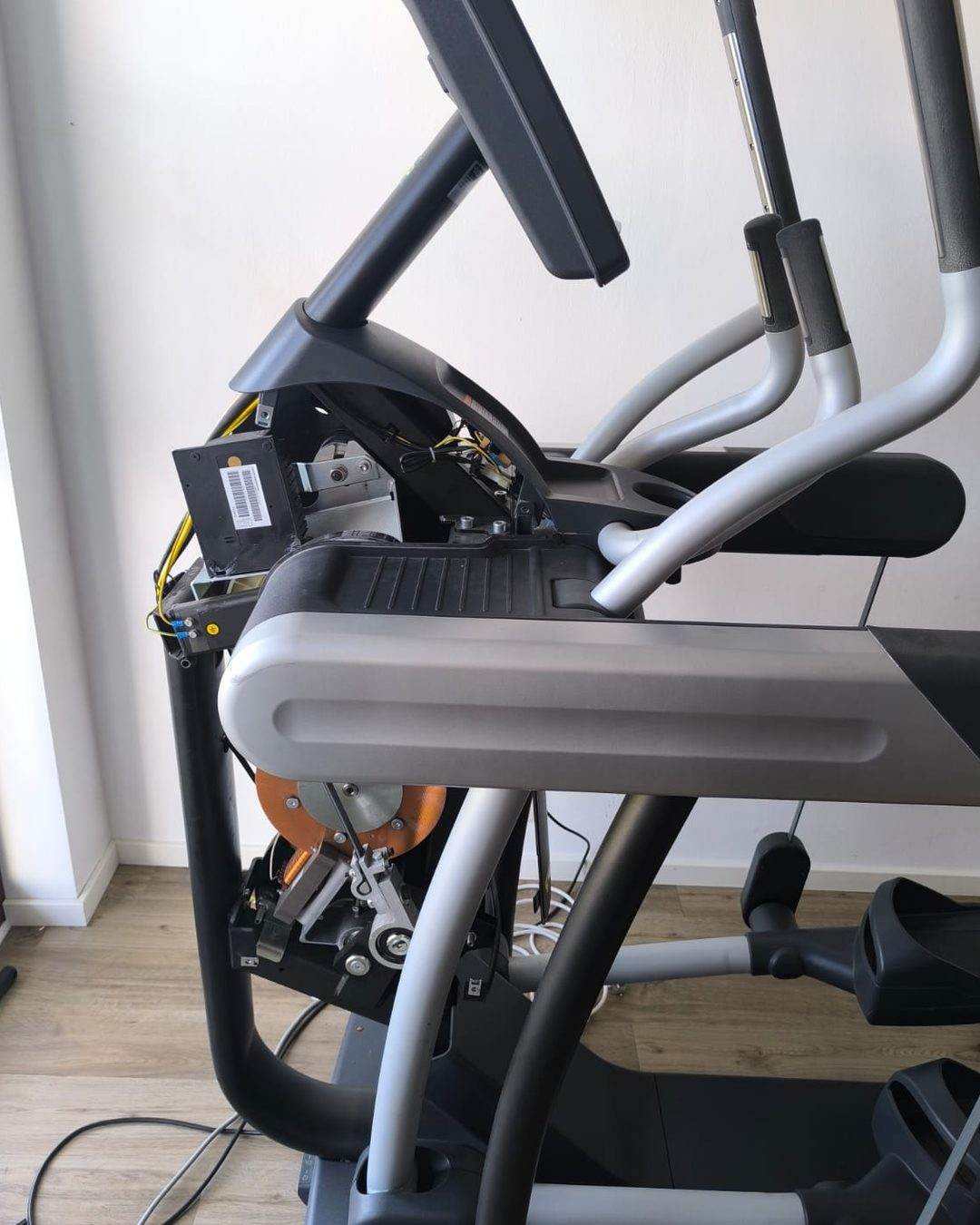 Opene Crosstrainer bei der Reparatur: ofmontéiert Konsol, siichtbar Elektronik an Undriffseenheet