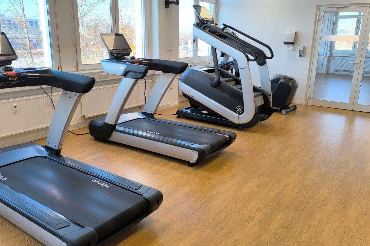 Fitnessraum zu Lëtzebuerg mat enger Rei Laafbänner an engem Trapesteiger
