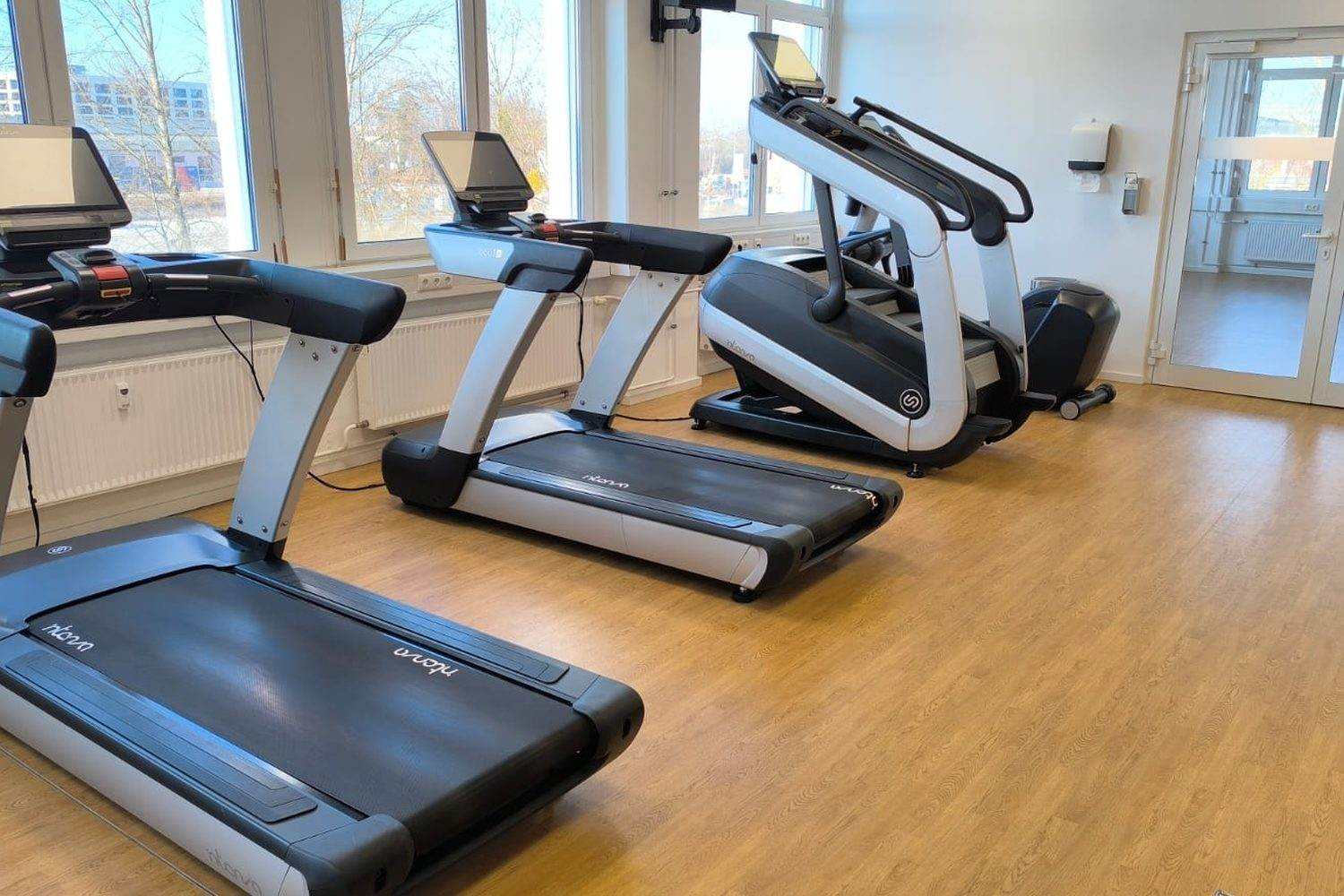 Fitnessraum in Luxemburg mit einer Reihe Laufbänder und einem Treppensteiger
