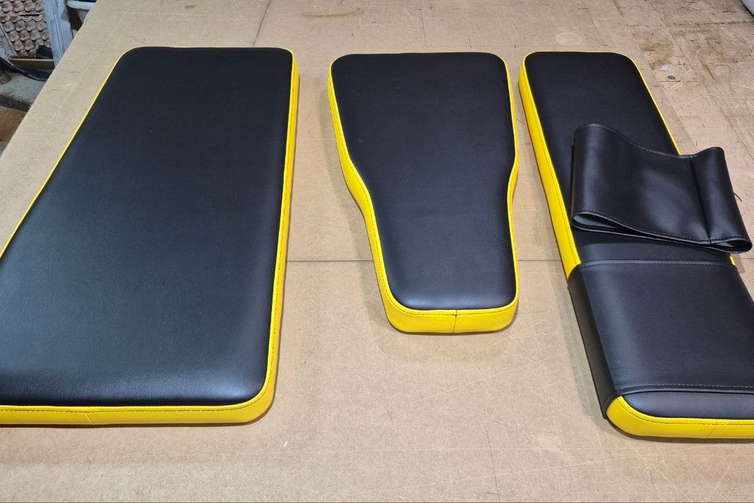 Jeu de garnitures refaites en noir avec passepoil jaune sur l’établi