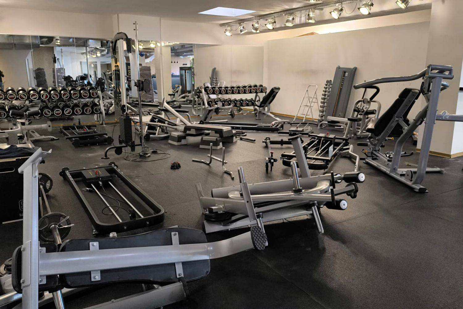 Machines de musculation et bancs en cours de montage dans une salle d’entraînement