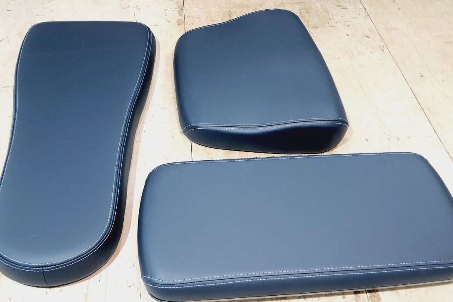 Three finished pads in dark blue, seams and edges even throughout