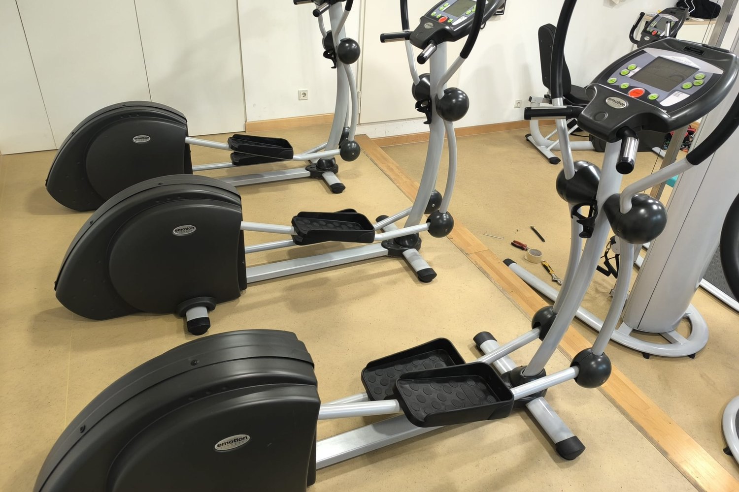 Rangée de vélos elliptiques, outillage posé au sol pour le contrôle