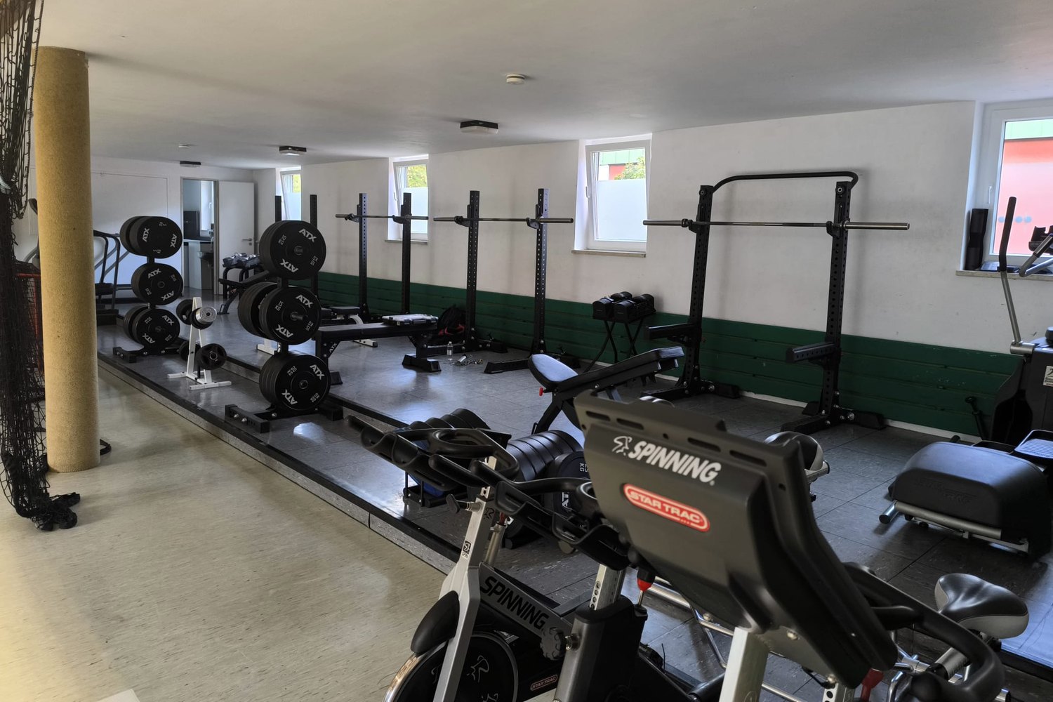 Espace musculation avec racks, barres et disques avant le contrôle