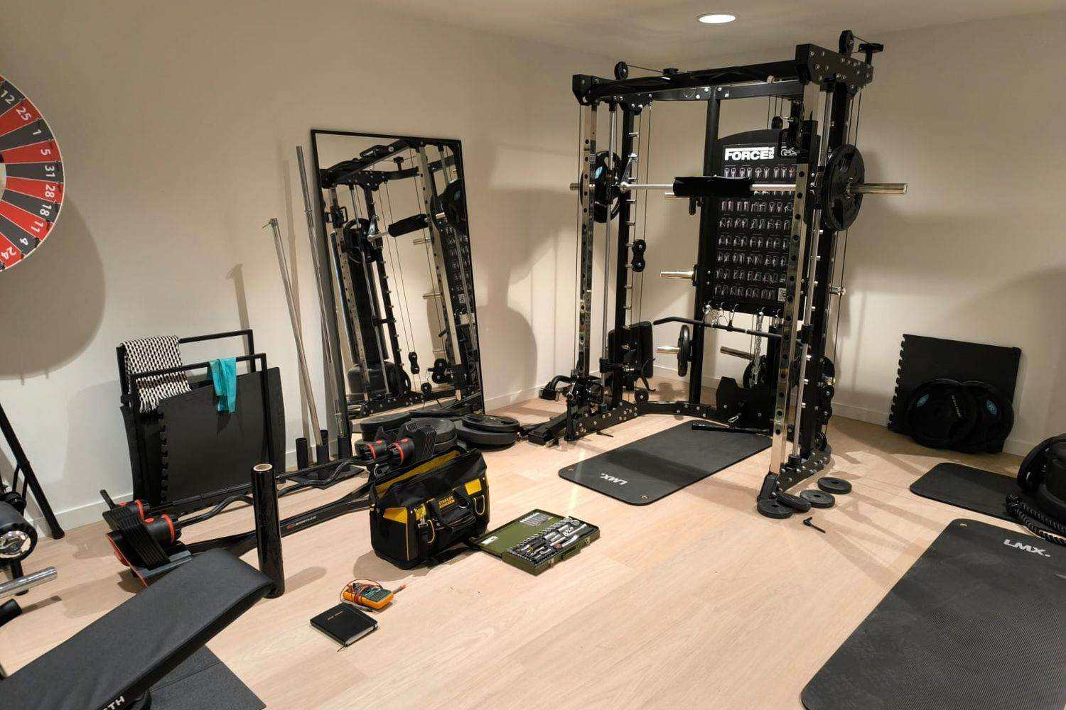 Multistation in einem privaten Home-Gym, Werkzeugtasche und Steckschlüsselsatz auf dem Boden