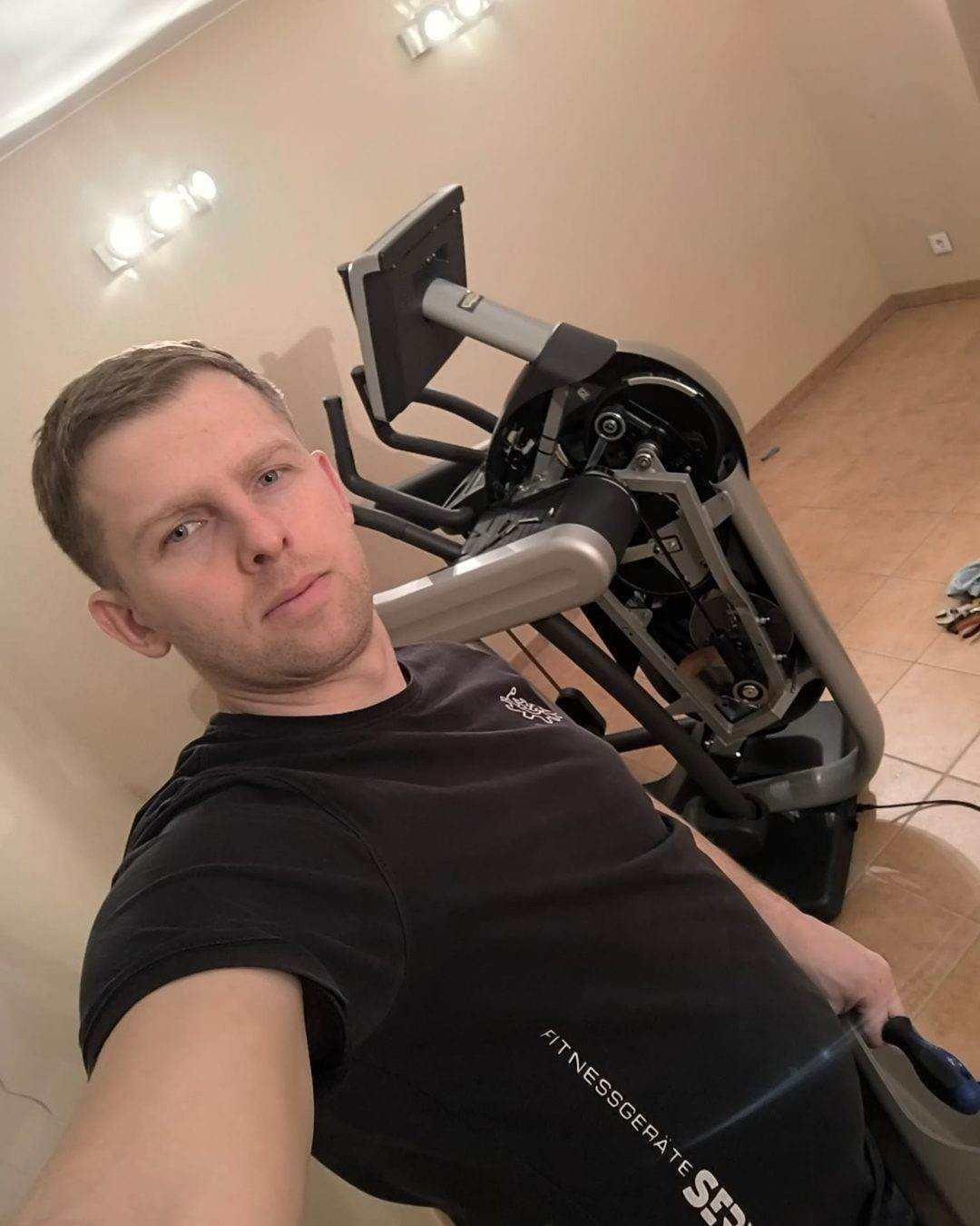 Technician beside a cross trainer with the drive cover removed, the internal mechanism visible