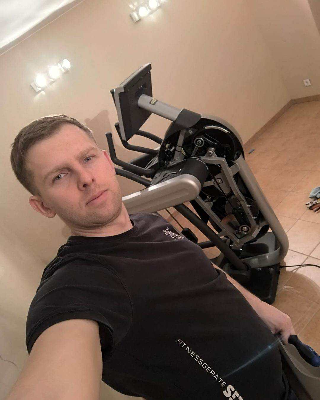 Technicien à côté d’un vélo elliptique dont le carter d’entraînement est déposé, mécanique interne visible